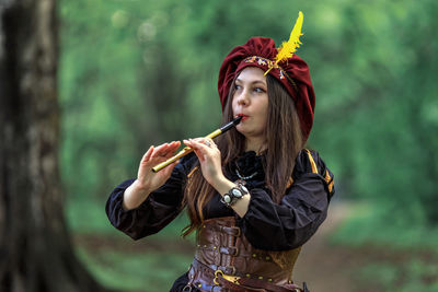 Young woman blowing bubbles while standing outdoors