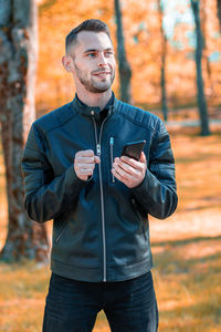 Young man wearing sunglasses standing on street during autumn