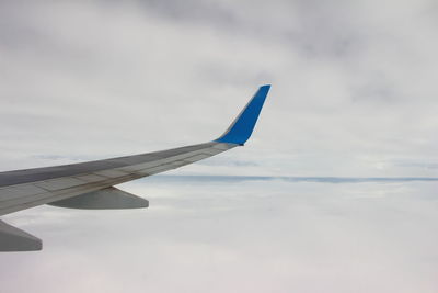 Close-up of airplane wing against sky