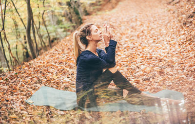 Portrait of young woman sitting on field