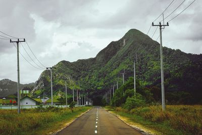 Road amidst plants and mountains against sky