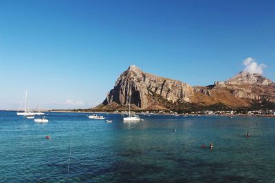 Scenic view of bay against clear blue sky