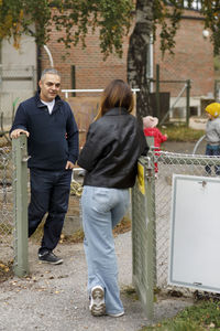 Man and woman talking at gate