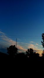 Silhouette of trees against sky at dusk