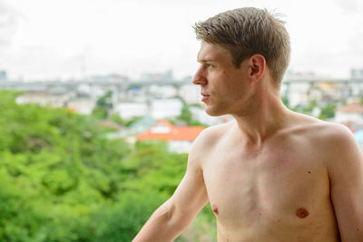 Portrait of young man looking away outdoors