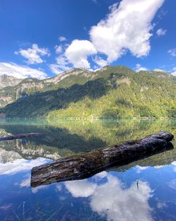 Scenic view of lake by mountains against sky