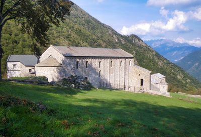 Built structure on field by mountain against sky