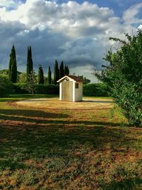 View of field against cloudy sky