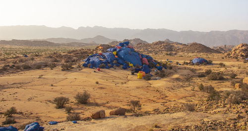 People on arid landscape against sky
