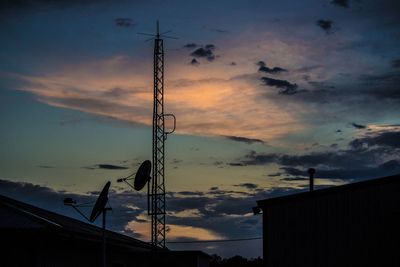 Low angle view of electricity pylon against sky during sunset