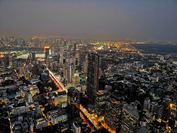 High angle view of illuminated cityscape against sky at dusk