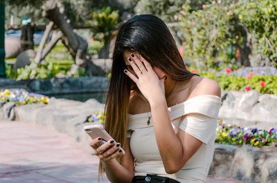 Low section of woman using mobile phone