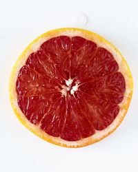 Close-up of orange slice against white background