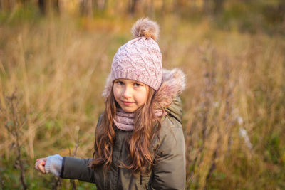 Little girl on yellow leaves background. girl in autumn forest. cute adorable child in fall park 