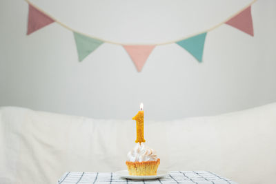 Close-up of cake with 1 candle on table