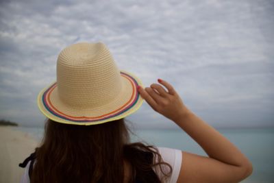 Rear view of woman wearing hat against sea