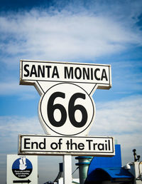 View of road sign against cloudy sky