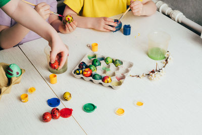 Children's hands that paint quail eggs for easter. preparing for a happy easter holiday