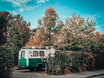 Car on road by trees against sky