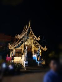 Statue of illuminated temple at night