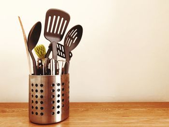 Close-up of cooking utensils in container on table
