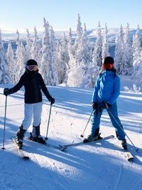 Full length of people skiing on snowcapped mountain