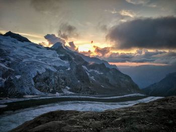 Scenic view of snowcapped mountains against sky during sunset