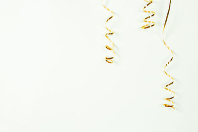 Gold serpentine isolated on light background. holiday decoration for parties, birthday, greeting 