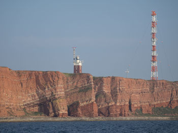 Lighthouse by sea against sky