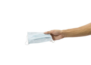 Close-up of hand holding umbrella over white background