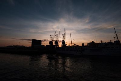 Ship at harbor against sky during sunset