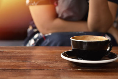 Midsection of coffee cup on table at cafe