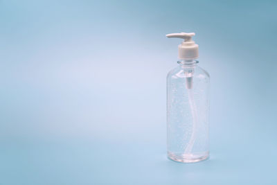 Close-up of glass bottle on table against blue background