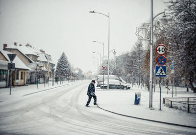 Man on snow covered field against sky