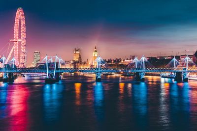 Illuminated bridge over river at night