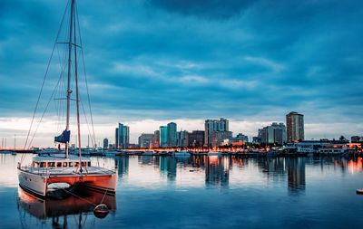 Sailboats moored in bay against sky