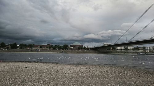 Bridge over river against cloudy sky