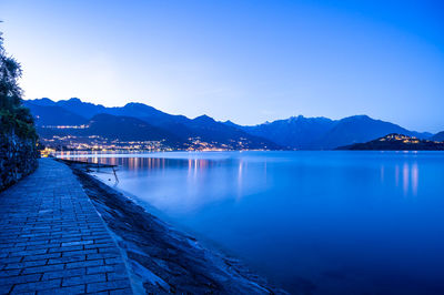 The town of pianello del lario, on lake como, and the promenade along the lake, at dusk. 