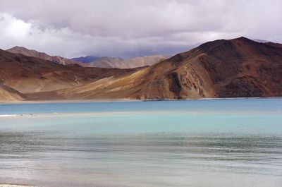 Scenic view of mountains against cloudy sky