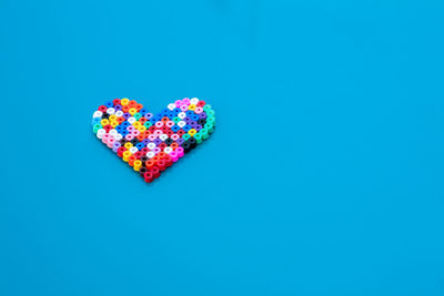 Close-up of multi colored umbrella against clear blue background