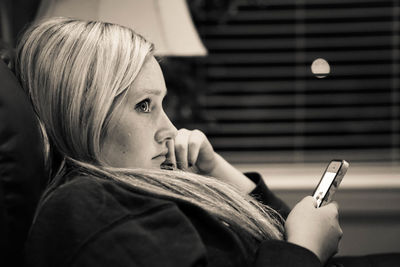 Side view of woman looking away while using mobile phone