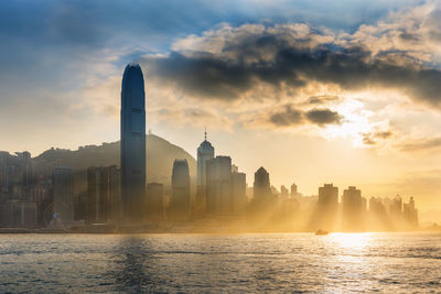 Modern cityscape against sky during sunset