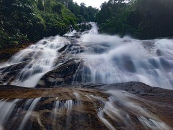 Low angle view of waterfall against sky