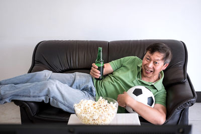 Full length of man sitting on sofa