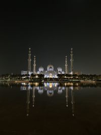 Reflection of buildings in lake at night