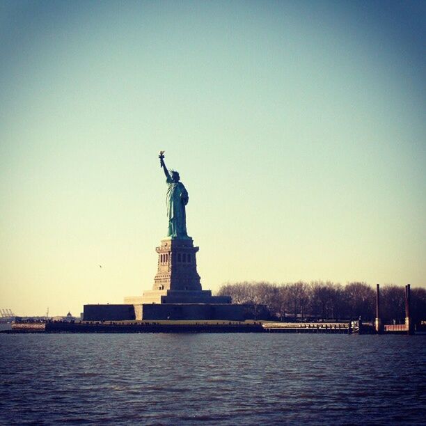 statue, sculpture, human representation, art and craft, art, clear sky, creativity, copy space, statue of liberty, international landmark, famous place, travel destinations, waterfront, water, travel, capital cities, tourism, built structure