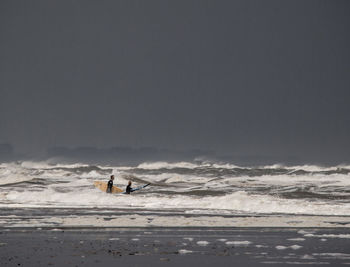 People on beach against sky