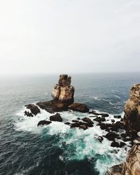 Rock formation in sea against sky