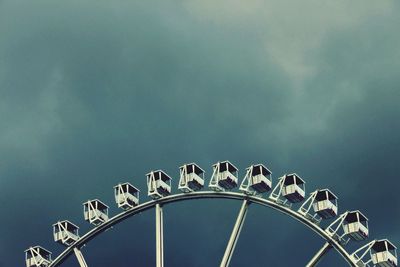 Low angle view of ferris wheel against cloudy sky at dusk