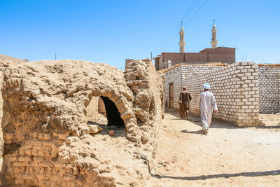 Rear view of man working at construction site against clear sky